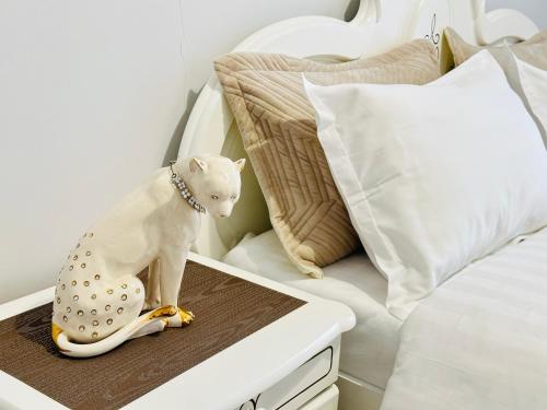 una figura de un gato sentado en una mesa junto a una cama en Grand champion en Astaná