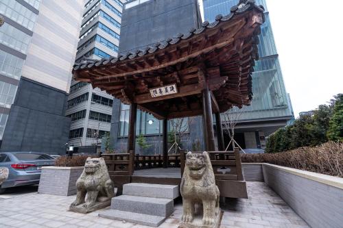 two statues of lions in front of a building at The Prima Hotel Jongno in Seoul