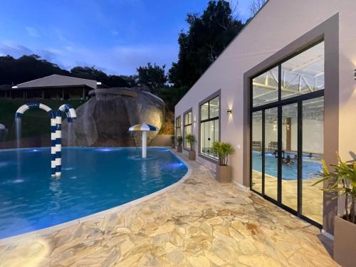 a swimming pool in a house with a resort at Hotel Campestre Atibaia in Atibaia