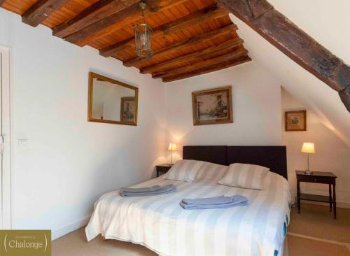 Un dormitorio con una cama con toallas azules. en L'éco-Domaine du Chalonge en Héric