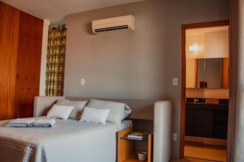 a bedroom with a bed and a air conditioner at Studio Nova Aliança 603 Fatesa, Unip, Vaga, Wifi in Ribeirão Preto