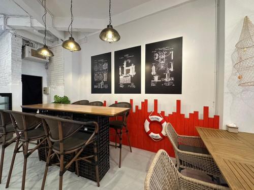 a dining room with tables and chairs and red dividers at Rema residence China town in Bangkok