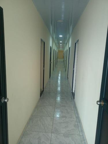 un corridoio vuoto con porte e pavimento piastrellato di Hotel Arci a Cúcuta