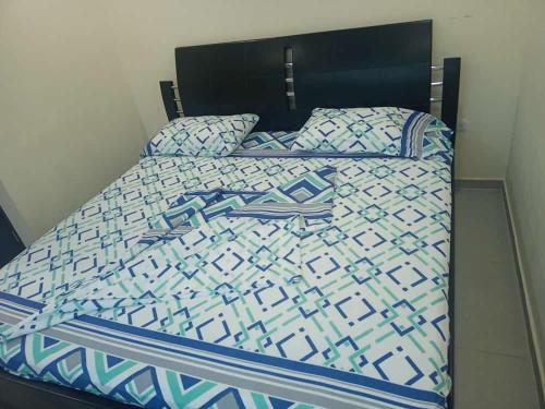 1 cama con edredón y almohadas azules y blancos en Hotel Arci, en Cúcuta
