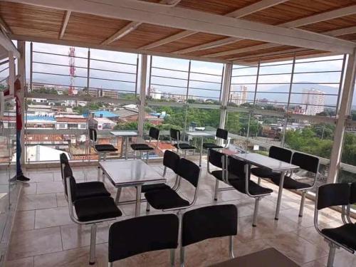 a large room with tables and chairs and windows at Hotel Arci in Cúcuta