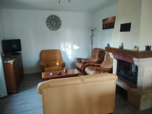 sala de estar con sofás, chimenea y reloj en maison en Périgord proche Beynac et Sarlat, en Cénac-et-Saint-Julien