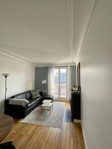 un salon avec un canapé et une table dans l'établissement Cosy apartment in Levallois, à Levallois-Perret