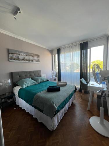 une chambre avec un lit, un bureau et une fenêtre dans l'établissement 130m2 de standing, 5min plages et stade, Parking gratuit, 5e et dernier étage avec ascenseur, vue montagne, à Marseille