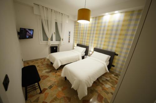 a room with two beds and a chair in it at Venezia House in Mestre
