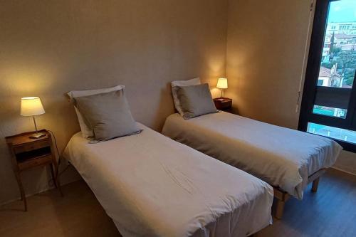 une chambre d'hôtel avec deux lits et une fenêtre dans l'établissement Vue mer exceptionnelle-piscine, à Saint-Raphaël