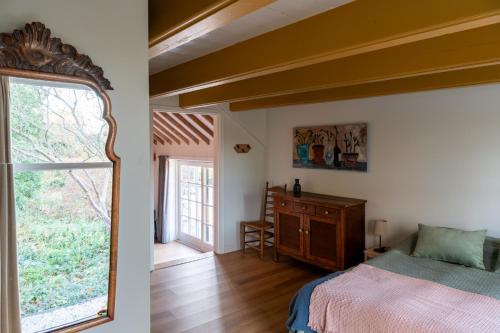1 dormitorio con cama y ventana grande en Kleinhoef - charmante, luxe kamers in een boerderij uit 1875 en Nigtevecht