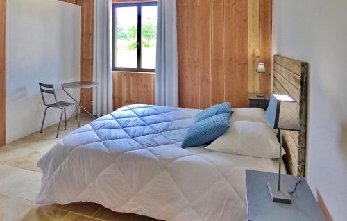 1 dormitorio con 1 cama grande con almohadas azules en Le Bois De La Fontaine, en Florimont-Gaumiers
