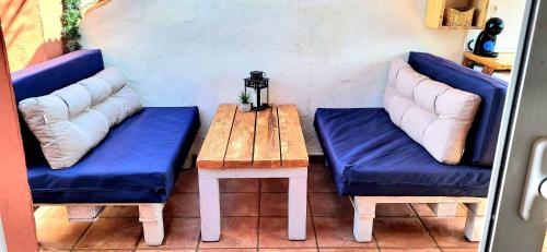 duas cadeiras azuis e uma mesa de madeira com um banco em Selwo Studio em Estepona