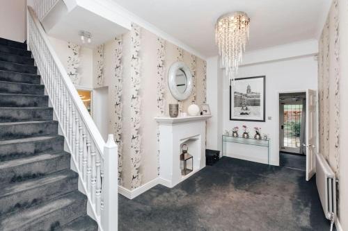 a staircase in a home with a chandelier at Wisteria House in Marlow