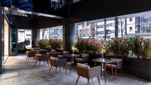 a restaurant with tables and chairs and plants at The Prima Hotel Jongno in Seoul