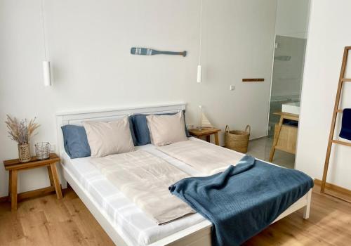 Pannonia Apartments في موربيش آم سي: غرفة نوم عليها سرير وبطانية زرقاء