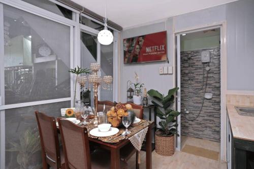 a dining room with a table and chairs and a dining room at Golden V Grandeuria Unit E in Malolos
