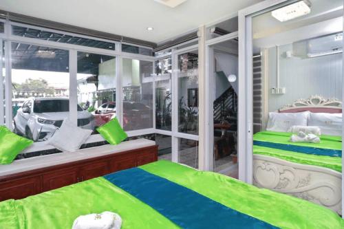 Un dormitorio con una cama verde y blanca y una ventana en Golden V Grandeuria Unit E, en Malolos