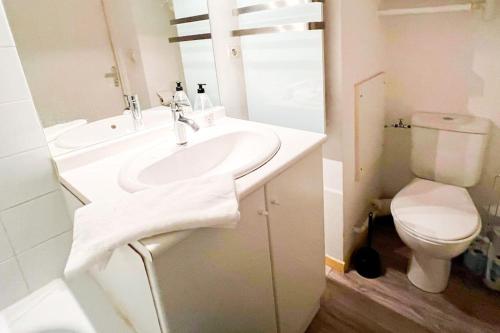 een witte badkamer met een wastafel en een toilet bij At the foot of the ramparts in a secure residence in Avignon