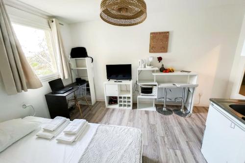 een witte kamer met een bed en een bureau bij At the foot of the ramparts in a secure residence in Avignon