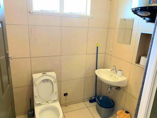 a small bathroom with a toilet and a sink at Royal Taste of Africa Apartments in Windhoek