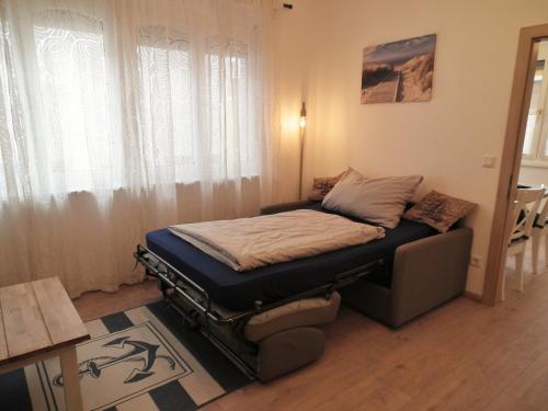 a small bed in a room with a window at Appartement blue Dinghi in Mörbisch am See