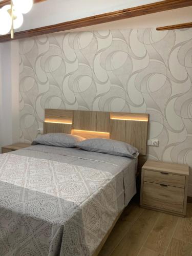 1 dormitorio con cama y pared con papel pintado en Casa Román, en Albarracín