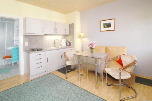 a kitchen and dining room with a table and chairs at Haus Waterkant in Breege