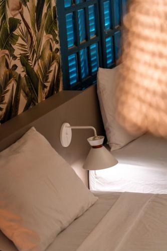 a bed with a lamp next to a pillow at Apprezzare . Pousada beira-mar in Porto De Galinhas