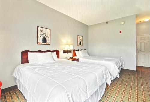 - 2 lits dans une chambre d'hôtel avec des draps blancs dans l'établissement Gasthof Amish Village INN, à Montgomery