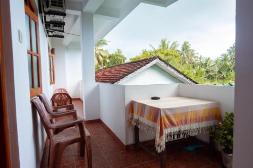 a room with a table and chairs and a window at SHYNI Guest House in Hikkaduwa