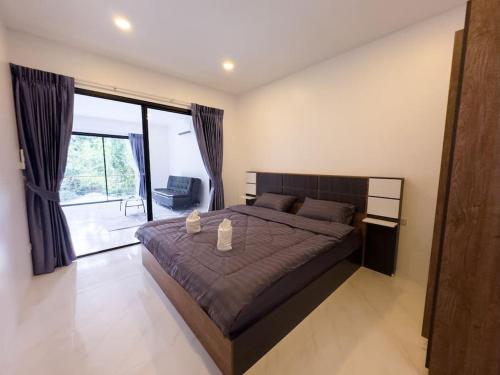 - une chambre avec un grand lit et une grande fenêtre dans l'établissement New above Chaweng - Inkl Scooter, à Nathon Bay