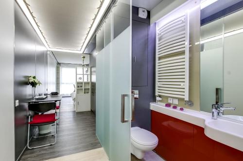 une salle de bain avec toilettes et lavabo dans l'établissement LOKORA REIMS, à Reims