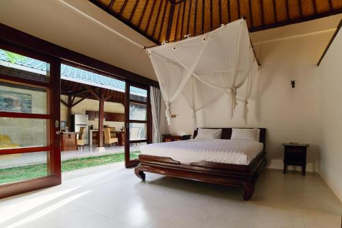 une chambre avec un lit à baldaquin dans l'établissement Cantik ArtVilla for big company by ArthouseBali, à Uluwatu