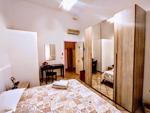 une chambre avec un lit, un bureau et un miroir dans l'établissement Domo Janas GuestHouse, à Olbia