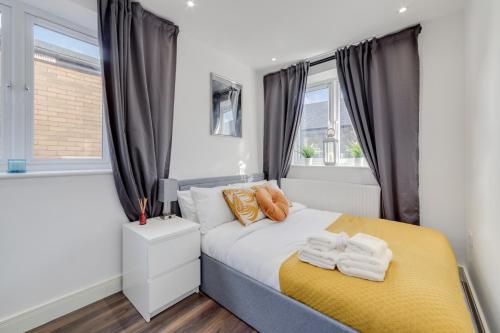 倫敦的住宿－Modern 1 Bed Apartment - Nine Elms, Battersea，一间卧室配有一张床,上面有两条毛巾