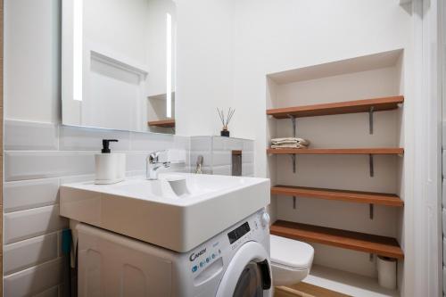 a bathroom with a sink and a washing machine at Cozy studio in the city center in Vilnius