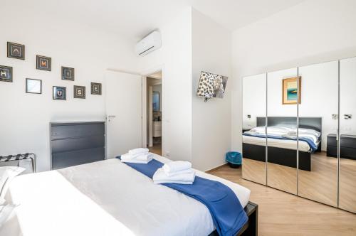 una camera da letto bianca con due letti e uno specchio di Charming Hideaway in Florence - Apt x4 a Firenze