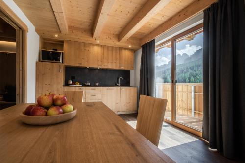 a kitchen with a table with a bowl of fruit on it at Chalet Alpenrose in Misurina