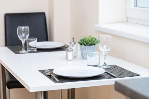 a table with plates and glasses on a counter at Sky Apartments Vienna in Vienna
