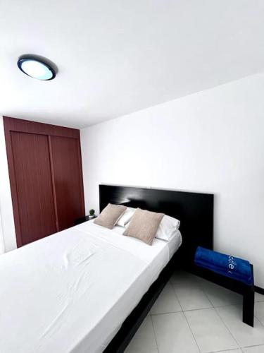 1 dormitorio con 1 cama blanca grande y cabecero negro en Bliss Apartments T3 - Zita - On The Beach en Mindelo