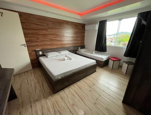 Habitación de hotel con 2 camas y ventana en Savanna Suites - Beto Carrero en Penha