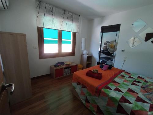 a bedroom with a bed and a window at Casa familiar con dos piscinas entre la playa y la ciudad in Otura