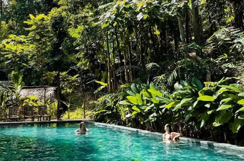 Tres personas en una piscina en un bosque en Puluong Aroma, en Hương Bá Thước