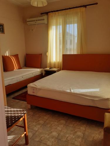 a bedroom with two beds and a window at THALIA'S GARDEN in Mytilini