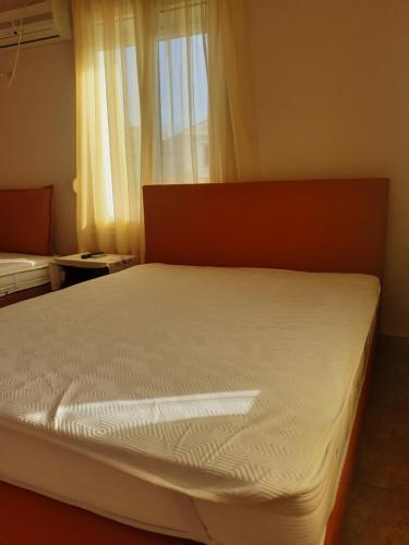 a large bed in a room with a window at THALIA'S GARDEN in Mytilini