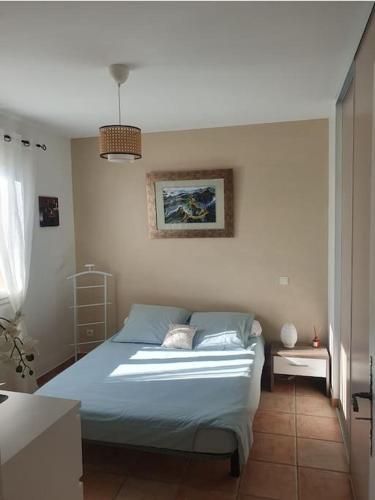 une chambre avec un lit avec des draps bleus et une fenêtre dans l'établissement Maison en Provence avec jacuzzi, à Peyrolles-en-Provence