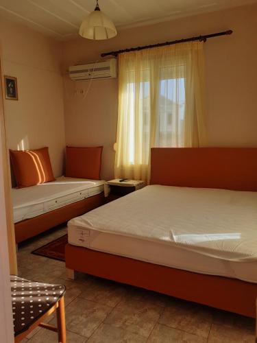 a bedroom with two beds and a window at THALIA'S GARDEN in Mytilene