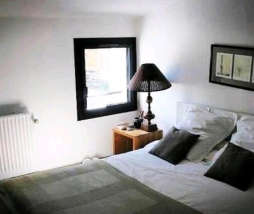 ein Schlafzimmer mit einem Bett und einem Tisch mit einer Lampe in der Unterkunft Grande maison en pierre dans la colline varoise in Vidauban