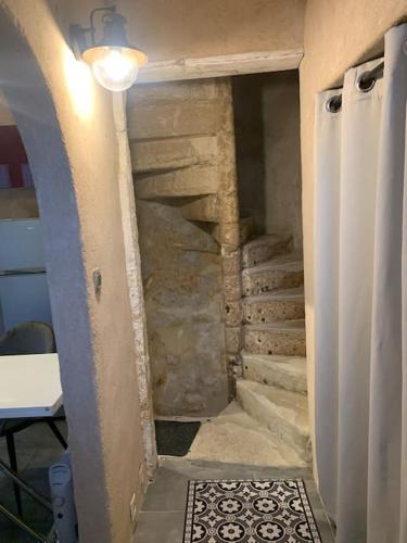 un escalier dans une chambre avec un mur en pierre dans l'établissement La Tour - Hyper Centre - Place du Palet, à Angoulême